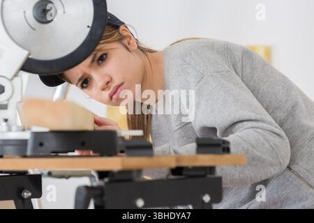 female apprentice in carpentry class using circular saw Stock Photo