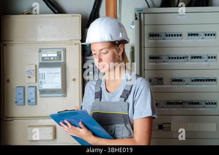 a lady inspecting a fuse board Stock Photo