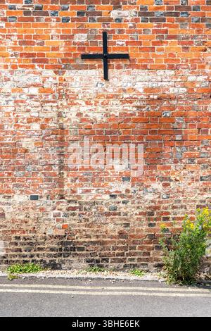 Old red brick wall with black metal wall tie Stock Photo