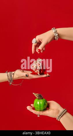 Pastry chefs holding mini apple-shaped cakes on red background Stock Photo