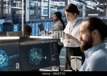 System administrators in data center integrating AI driven automation tools, doing maintenance. Staff members in server room using artificial intelligence machine learning models Stock Photo