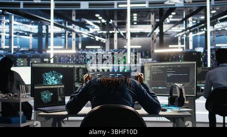 Irked data center admin raging because of malfunctioning node tree software analyzing datasets. Irascible server hub worker exasperated by visual programming tools not improving performance, camera A Stock Photo