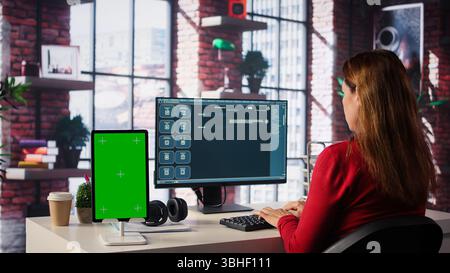 Freelancer interacting with smart AI virtual assistant next to mockup screen, using innovative chatbot web interface. Machine learning enhances productivity through advanced algorithms. Camera B. Stock Photo