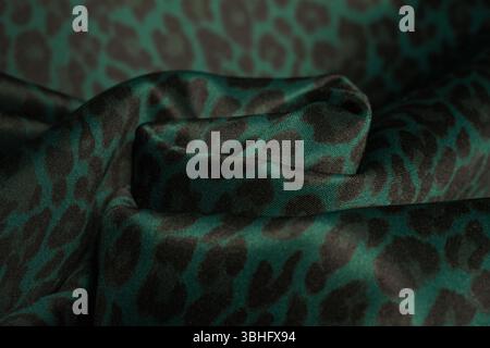Processed collage of extravagant wavy polyester thick cloth fabric neoprene with green leopard print, used for casual and sporty clothing. Stock Photo