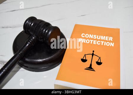 Concept of Consumer protection write on book and gavel isolated on Wooden Table. Stock Photo