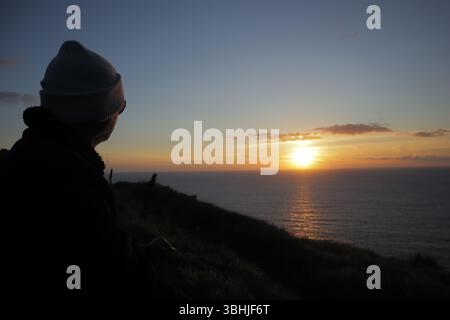 Peaceful Relaxing Deep Spiritual Thoughts against Golden Sunset, A Tranquil Late Evening over Atlantic Ocean Sky, Sunset over Cliff of Moher Stock Photo