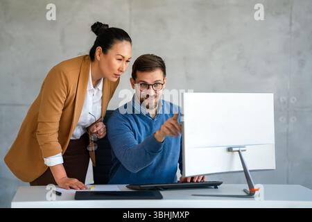 Business professionals collaborating on a project in a modern office. Team of coworkers sharing idea Stock Photo