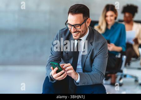 Happy businesspeople laughing while collaborating on a new project in an office. Stock Photo