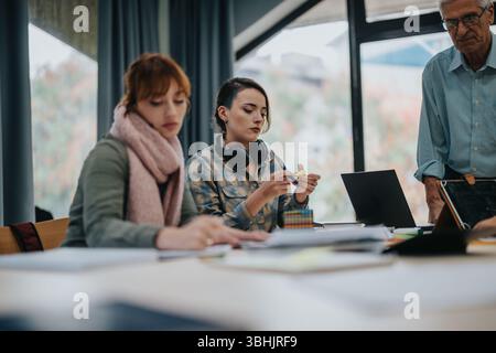 University students collaborating on a project with senior professor guidance Stock Photo