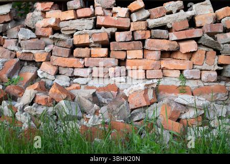 The red brick wall of the old, ruined, part of an ancient wall. Background images and textures. Construction waste close-up Stock Photo