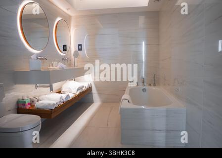 Modern Bathroom with Marble Walls, Dual Sinks, and Bathtub Stock Photo