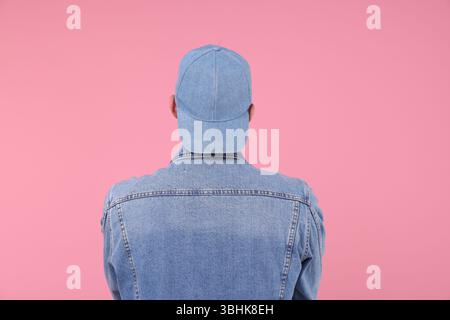 Young man wearing stylish denim baseball hat on pink background Stock Photo