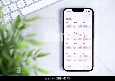 Poznan, Poland - June 10, 2025: NEW IOS 26 and NEW Liquid Glass IN DESIGN mobile device displaying 2025 calendar, illustrating organized future planni Stock Photo