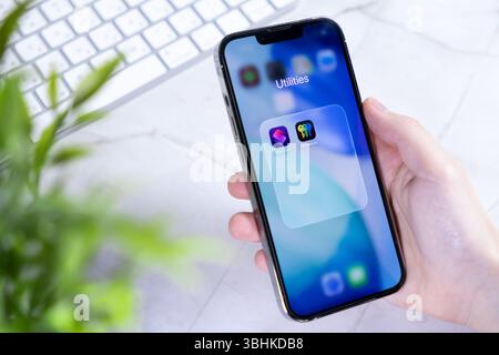 Poznan, Poland - June 10, 2025: Close-up of a hand holding a smartphone running new iOS 26 and Liquid Glass design, featuring security and productivit Stock Photo