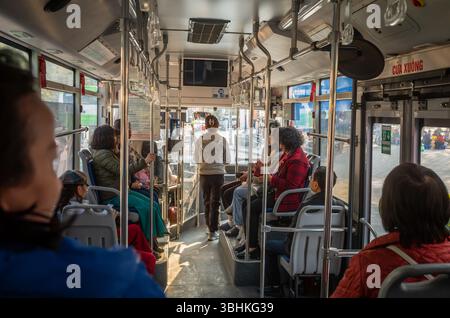 Vietnamese passengers travelling on a public bus in central Hanoi, Vietnam. Stock Photo