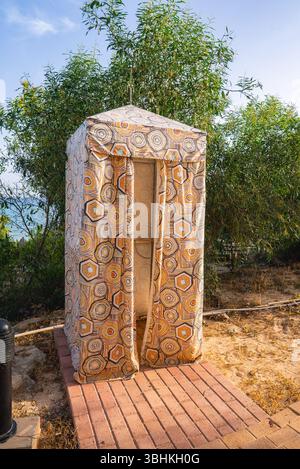Hexagonal Fabric Covered Structure Near Coastal Foliage and Sea Stock Photo