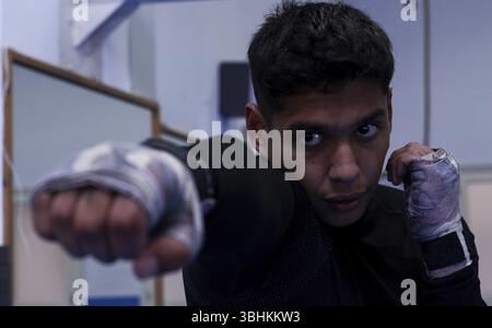Latin professional boxer throwing a punch while training boxing in the gym Stock Photo