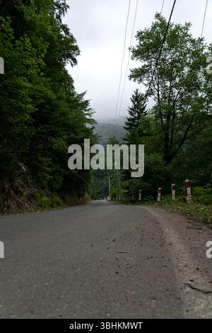 The road leading down. Mountains on the background, cloudy sky, Georgia Stock Photo