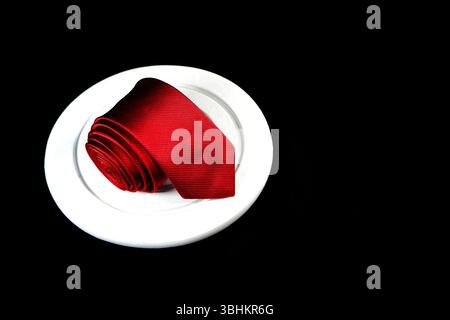 A red tie rolled on black background closeup shot with copy space Stock Photo