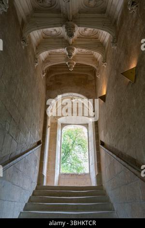 Arched Renaissance staircase window overlooks gardens and fills stone stairwell with natural light in Azay le Rideau. Stock Photo