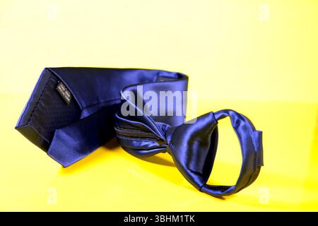 Blue color zipper tie folded isolated on yellow background closeup view Stock Photo