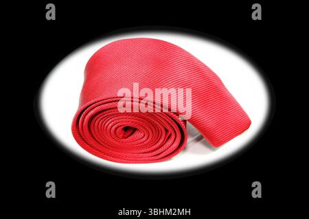 Red tie rolled isolated on black and white background close-up view Stock Photo