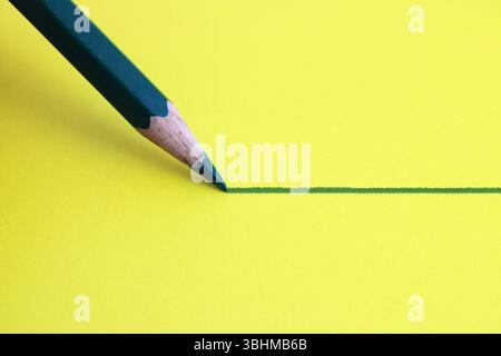 Dark green pencil drawing a straight line Stock Photo