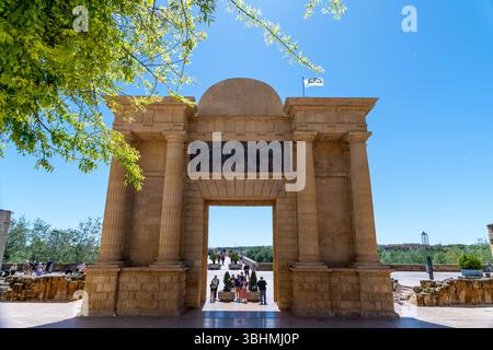 Cordoba, Cordoba - Spain - 04-08-2024: The monumental Puerta del Puente, a historic gateway in Cordoba, framed by greenery and a clear blue sky. Stock Photo