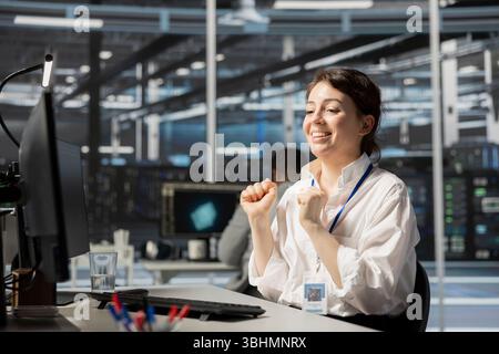 Joyous IT expert in data center office satisfied after checking report showing stable equipment performance. Happy server hub staff member relieved after successfully completing operations. Stock Photo