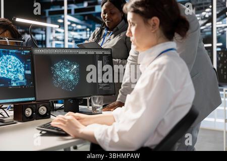 Data center team of programmers using artificial intelligence neural networks technology. Server farm coworkers using AI programming language on computer to update equipment Stock Photo