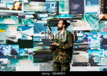 Officer monitoring real time combat data using advanced military systems, cyber tactics and digital surveillance to ensure battlefield control and strategic defense. War planning. Stock Photo