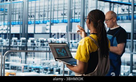 Engineering team working in smart factory, collecting and analyzing data. Teamworking colleagues using tracking software in industry 4.0 industrial plant equipped with advanced sensors, camera A Stock Photo