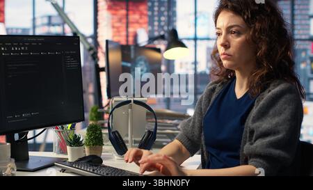 Admin writing code and doing maintenance on artificial intelligence neural networks computerized model. Woman tech support expert doing checkup on AI systems, data science. Camera B. Stock Photo