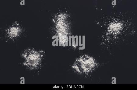Sprinkled wheat flour splash spots on black background Stock Photo
