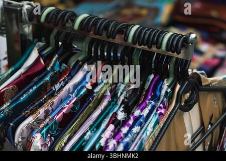 Vibrant silk robes displayed in a local Hanoi market, reflecting Vietnam’s rich textile traditions and craftsmanship Stock Photo