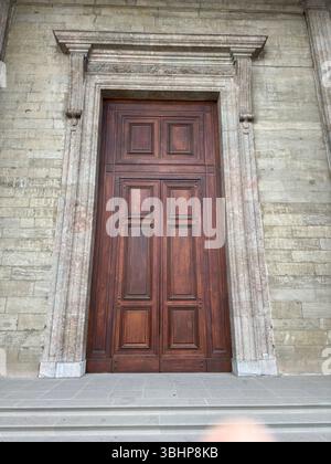 An impressive wooden door with an elegant stone framework. Stock Photo