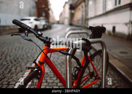 Orange bicycle stands on the orange bicycle park Stock Photo