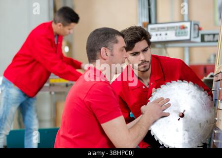 student and teacher in carpentry class using circular saw Stock Photo