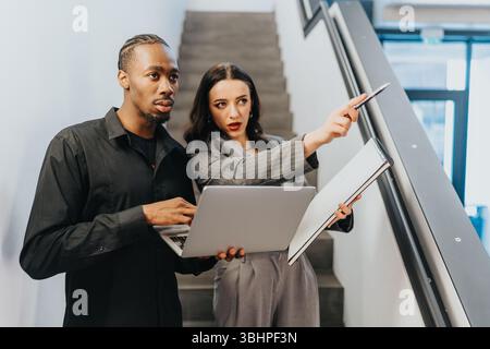 Collaborative discussion between diverse business colleagues on a staircase Stock Photo
