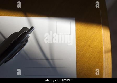 pen and white postcard on table Stock Photo
