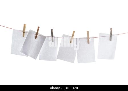 Clothesline with blank sheets of paper hung up with wooden clothespins isolated on a white background, mock up, copy space Stock Photo
