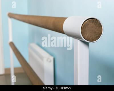 Selective focus close-up on the stand of a ballet (dance or gymnastics) barre installed against the wall Stock Photo