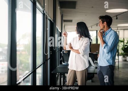 Cheerful diverse coworkers having fun during work break using technology enjoying working together Stock Photo