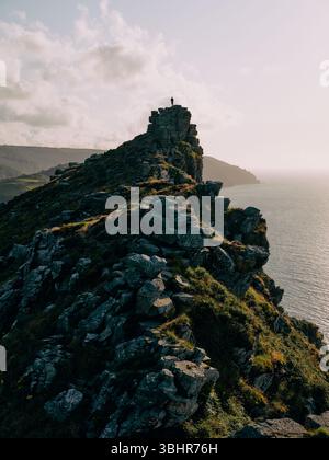 Lone figure standing on top of the Valley of Rocks, or Valley of the Rocks, on the coast in Lynton, North Devon, England UK - adventure explore Stock Photo