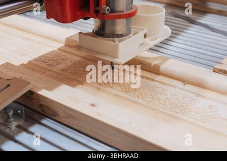 Close-up of automated machine cutting wooden board. Creative. Professional machine for industrial carving of wooden products Stock Photo