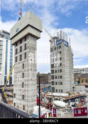 Construction site with two high-rise buildings under development surrounded by cranes and newcastle  skyline with concrete lift cores Stock Photo