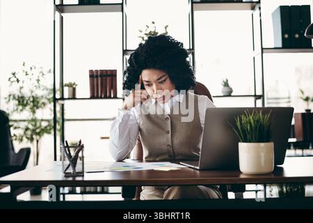 Businesswoman Working in Office with Focused Expression, Engaged in Professional Tasks and Occupation Stock Photo
