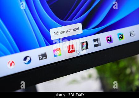Poznan, Poland - June 6, 2025: Adobe Acrobat application icon displayed on a Windows 11 desktop taskbar, with a cursor pointing to it for digital docu Stock Photo