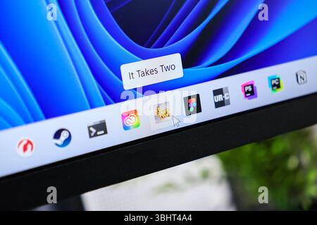 Poznan, Poland - June 6, 2025: It Takes Two game icon on the modern Windows 11 desktop taskbar, with a cursor hovering displaying its title tooltip Stock Photo
