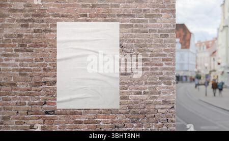 Urban street scene with blank poster on brick facade near sidewalk. Perfect mockup for promoting prints, ads, or visual content. Stock Photo